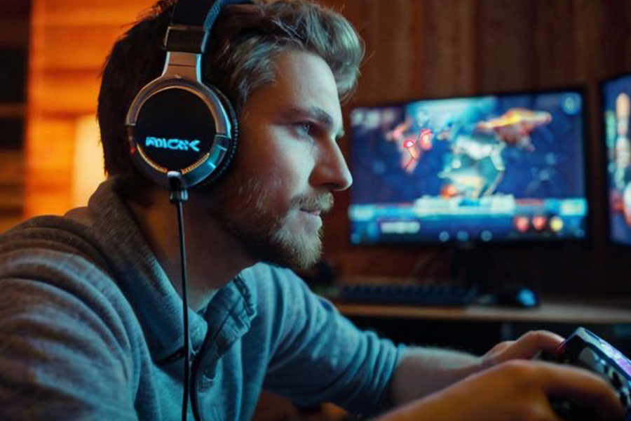 a streamer in front of his pc setup streaming games. becoming a streamer an expanding your boundaries is great way on how to become a popular gamer