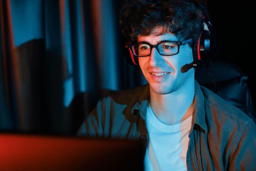 Picture of a Gamer with Gaming Glasses playing. you should consider knowing gaming glasses benefits.