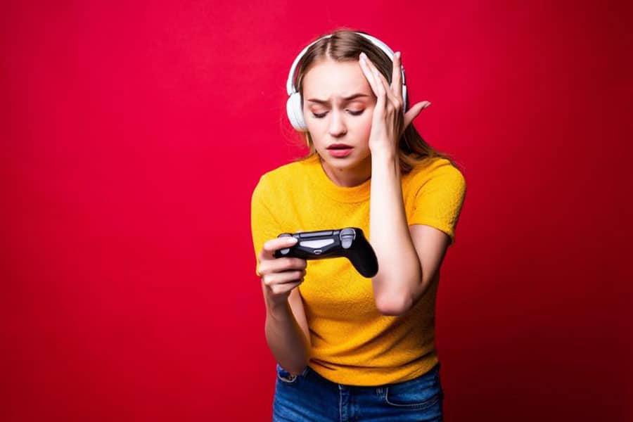 Picture of a Gamer Girl experiencing headache while playing video games.