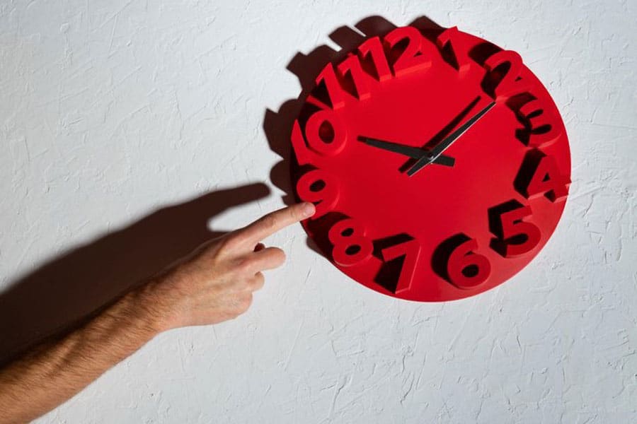 A hand pointing to a clock