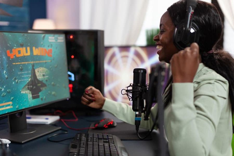 A game content creator behind a microphone expressing her happiness for winning the game.