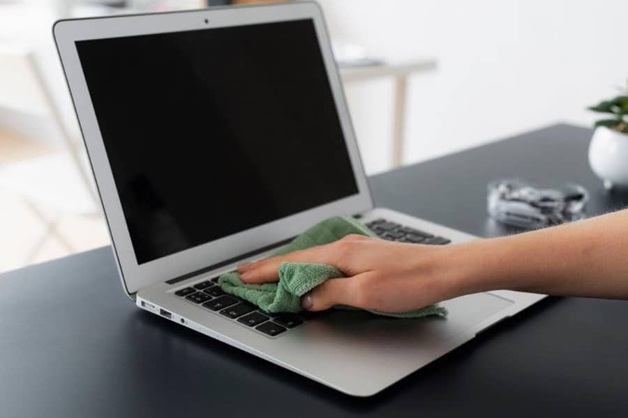 Picture of a person cleaning her Laptop. Cleaning is a great way for pc optimization for gaming.