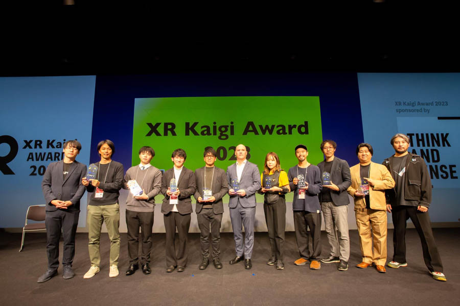 sponsors of XR Kaigi 2024 standing in front of a billboard of XR Kaigi 2024.